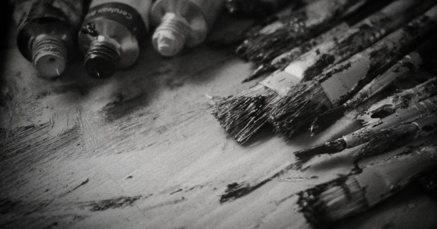 A black and white photograph of dirty paintbrushes