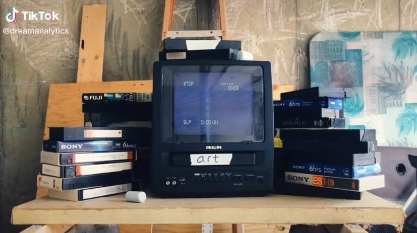 A still from the TikTok account Dream Analytics, featuring an old television with a VHS player attached