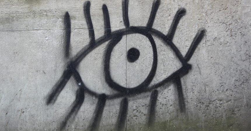 A graffiti drawing of an eye on a cement wall