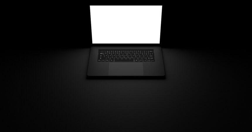 a laptop with a white screen in a dark room