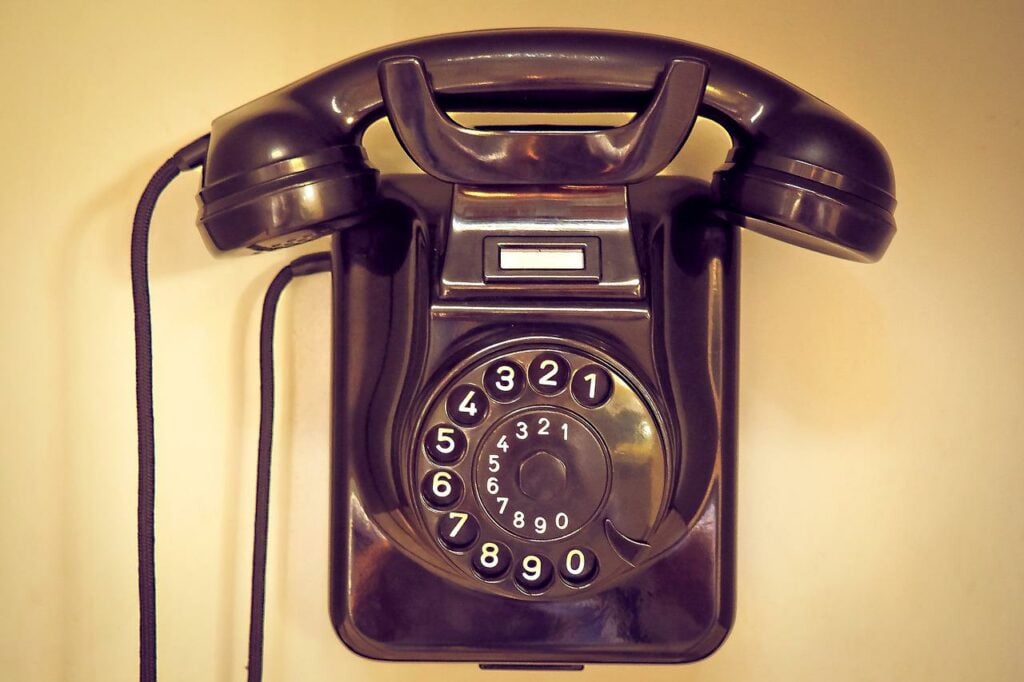 A black Bakelite telephone with a dial