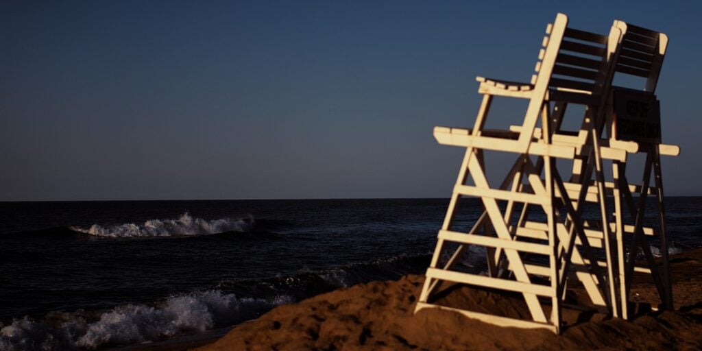 A beach in Montauk, Long Island with two life guard chairs looking out