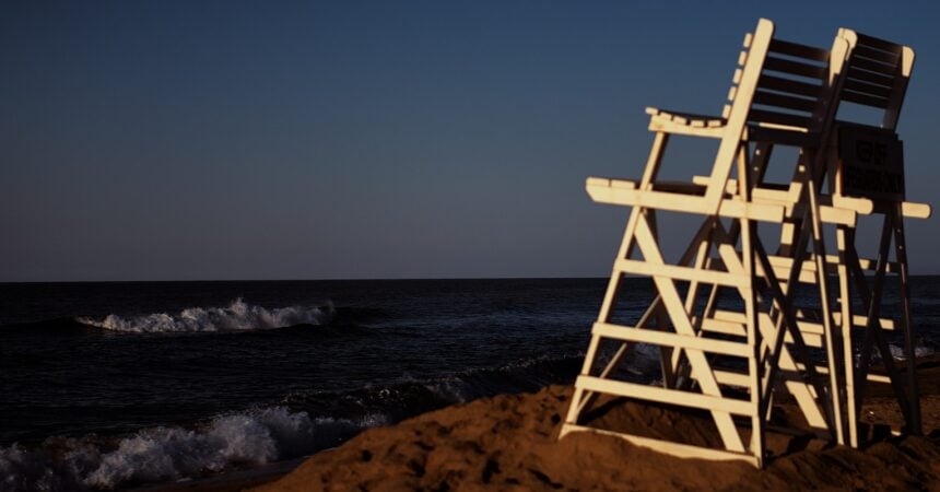 A beach in Montauk, Long Island with two life guard chairs looking out