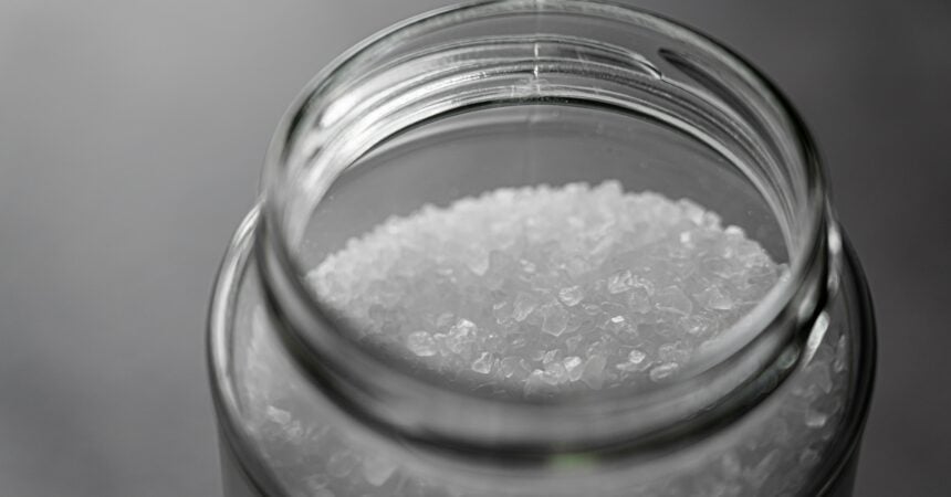 Looking down into the mouth of a glass jar filled with salt