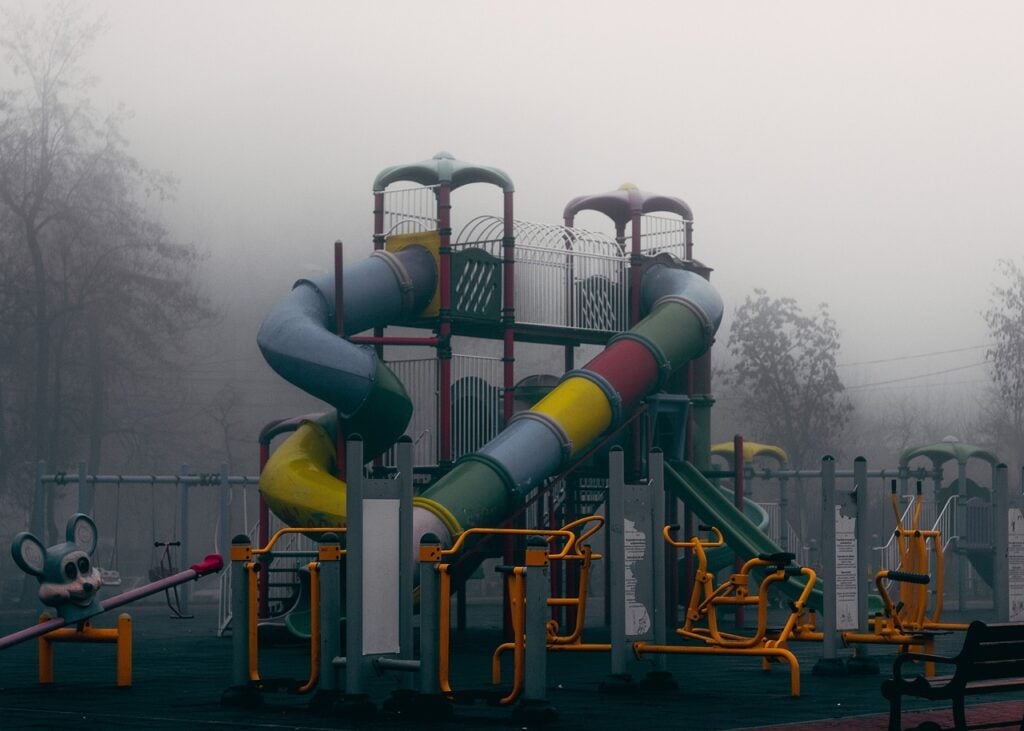 A playground slide, looking mysterious in the mist