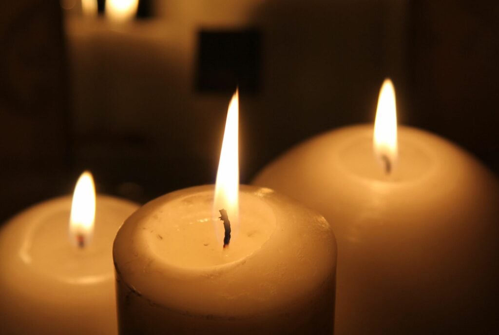 Three lit candles in the dark
