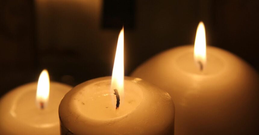 Three lit candles in the dark