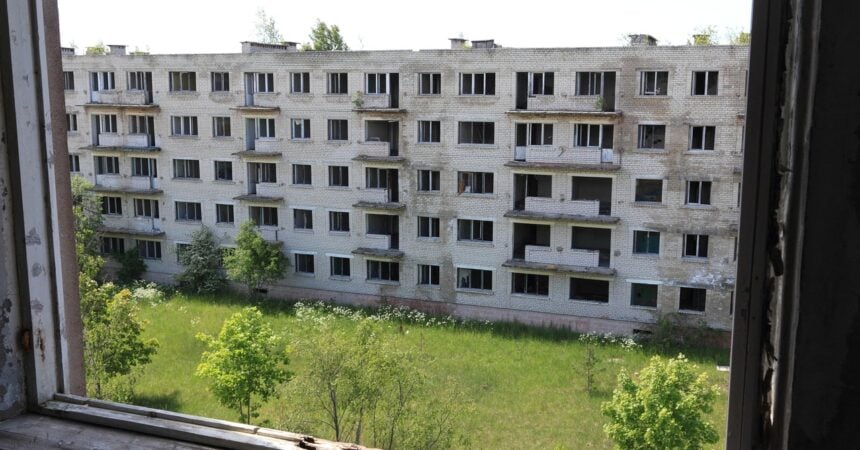 The exterior of a large, abandoned apartment building