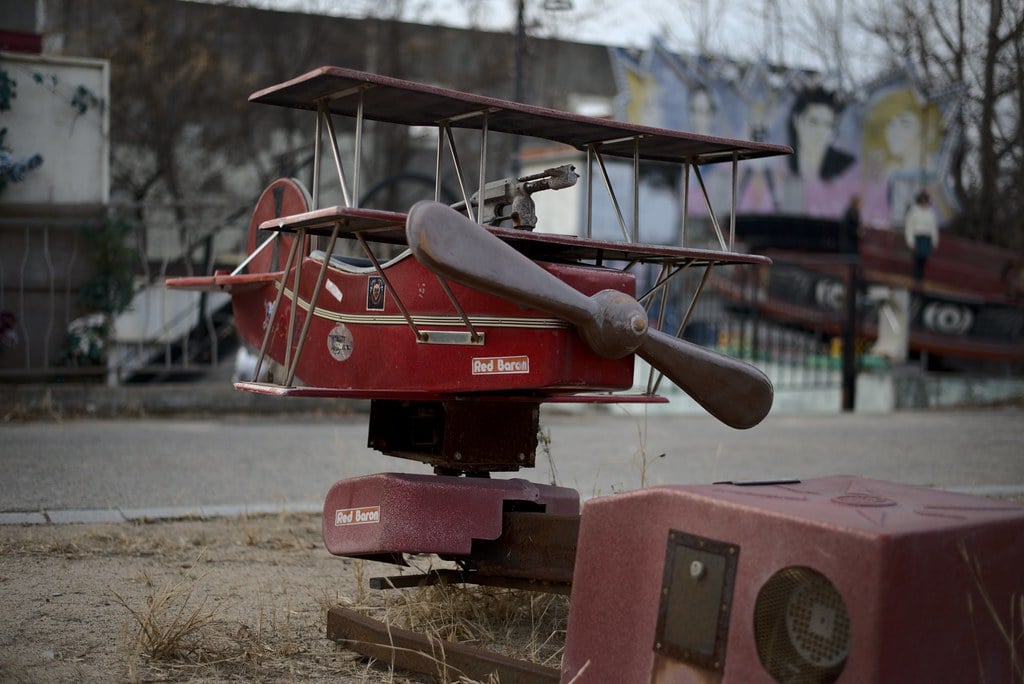 A ride-on airplane attraction at Yongma Land. The plane is a red biplane.