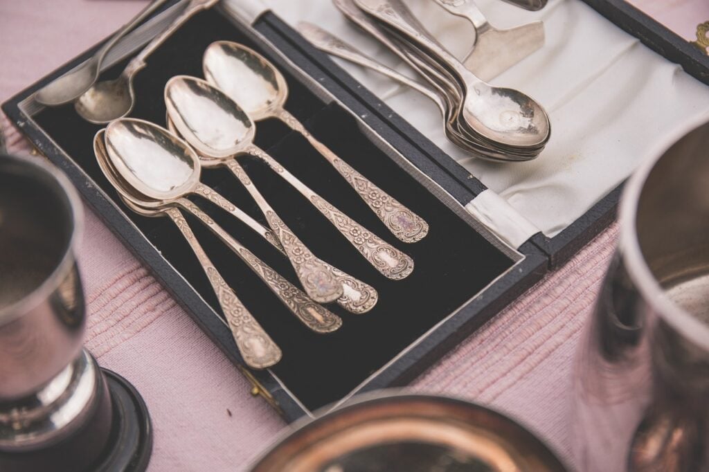 a tray of antique silver spoons