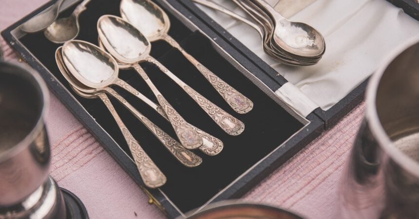 a tray of antique silver spoons