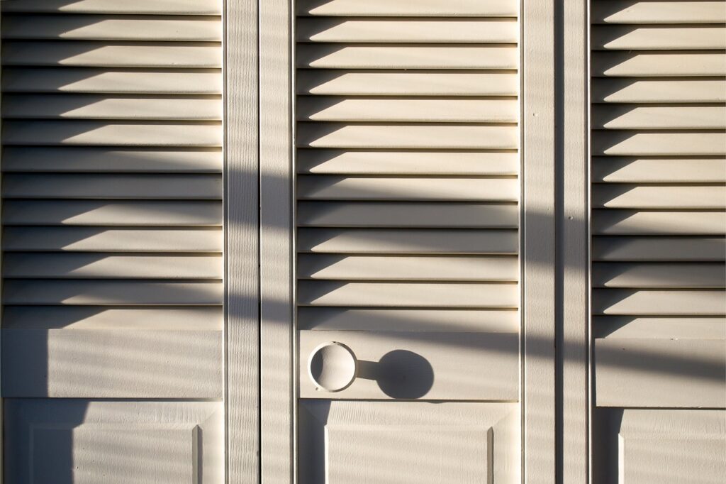 A white wood vertical tri-fold closet door