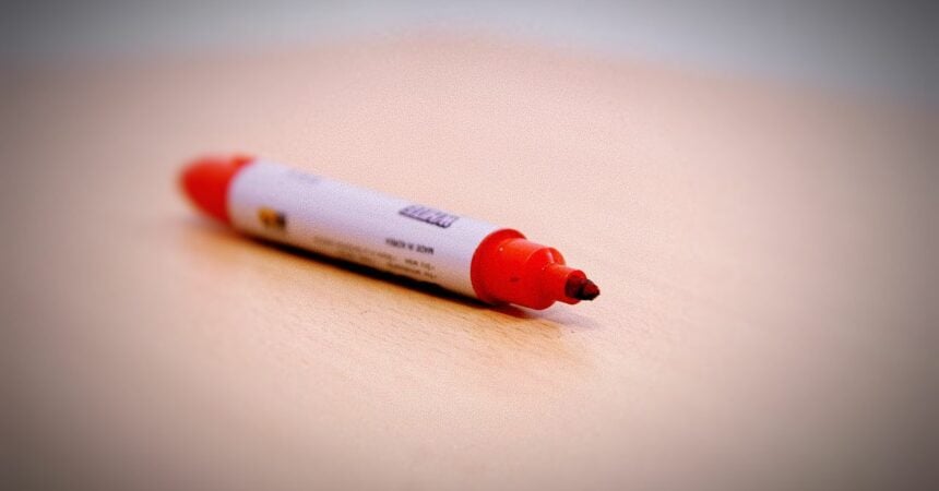a red marker on a wooden table