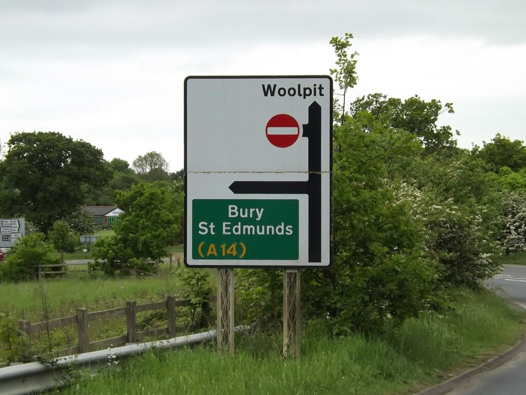 A road sign pointing towards Woolpit