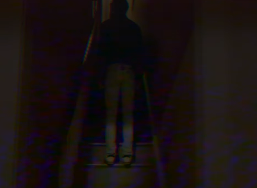 A screenshot from the web series Doors depicting a man named Jonathan standing on a set of stairs in the dark