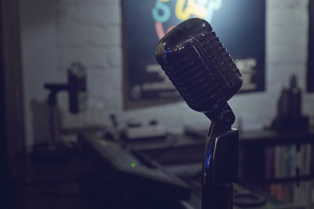 an old-style microphone for recording vocal music in a dark room with white-painted brick walls