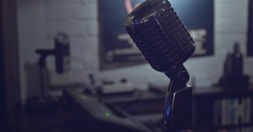 an old-style microphone for recording vocal music in a dark room with white-painted brick walls
