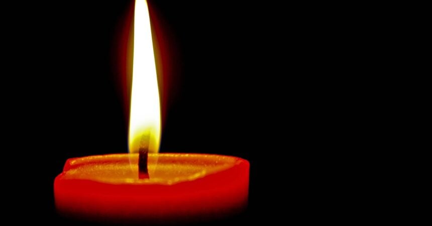 a red candle, lit in the dark