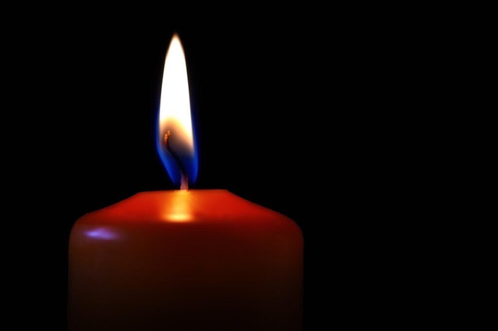 aa red candle lit in the dark