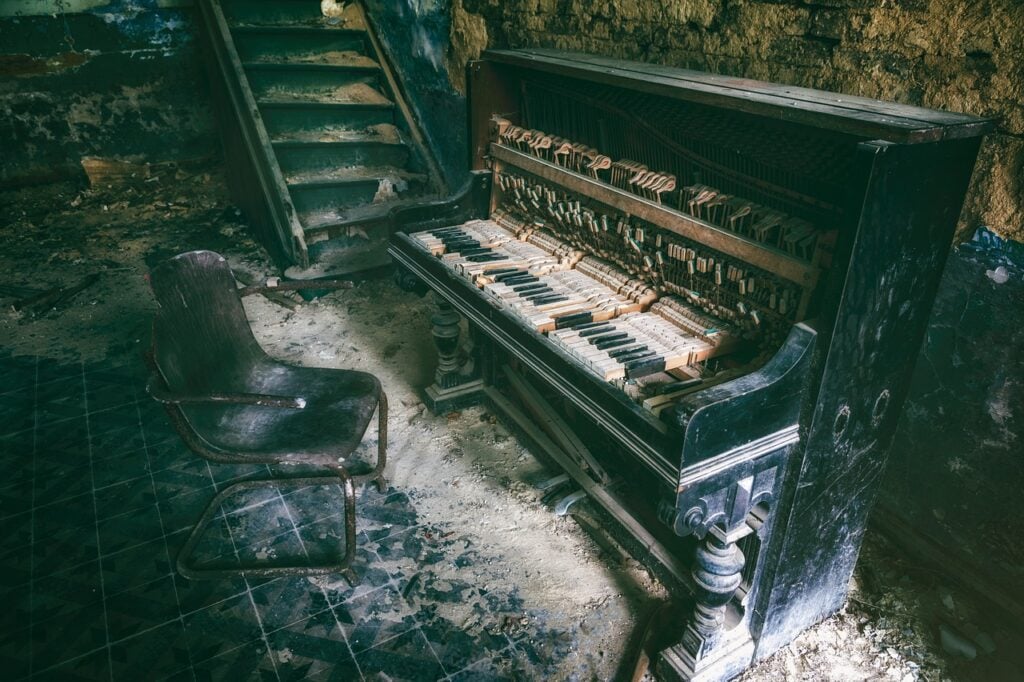 an old, broken piano in a destroyed room