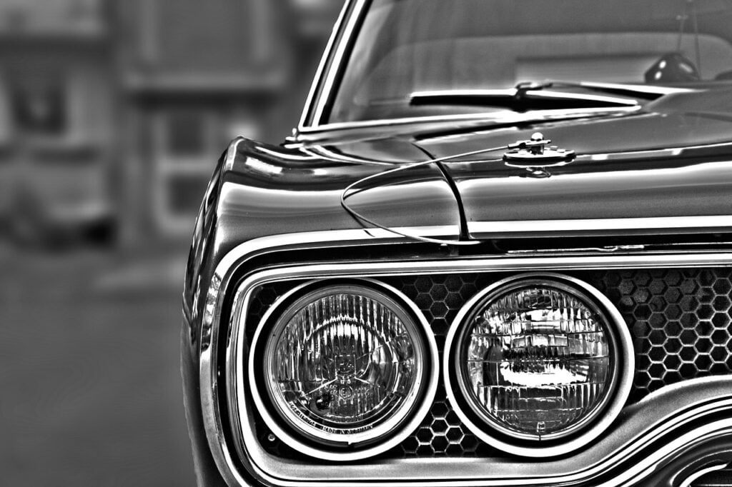 black and white close-up shot of headlights on a car
