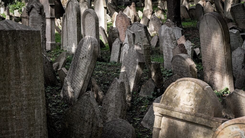 lots of old, crooked headstones in a cemetery