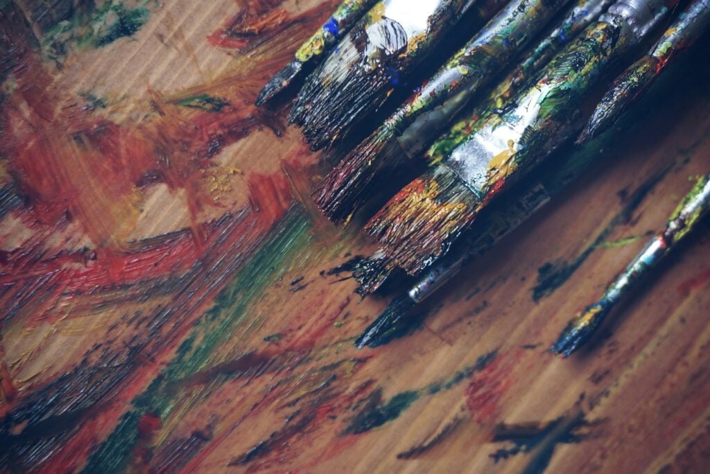 paint brushes and paint on a wood surface