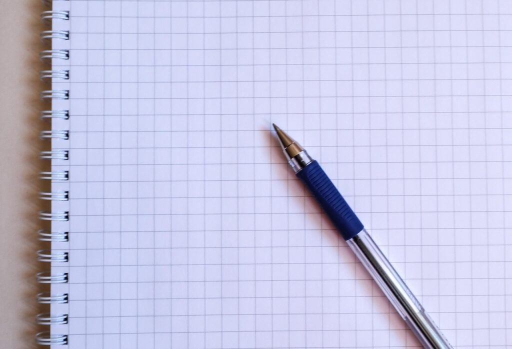 a blue ballpoint pen lying on a piece of graph paper