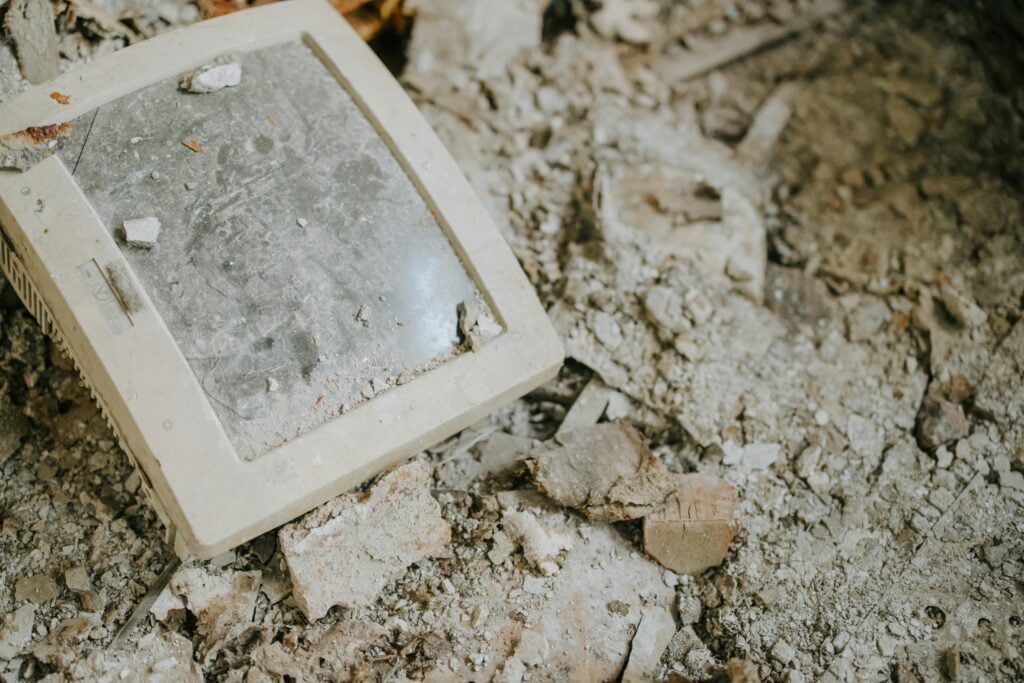 a dusty, broken computer monitor on a dusty, broken floor