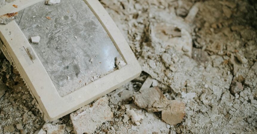a dusty, broken computer monitor on a dusty, broken floor