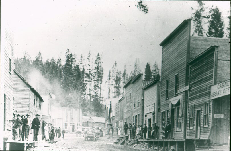 an old black and white photograph of Garnet, Montana at the turn of the century showing wooden buildings along a main street