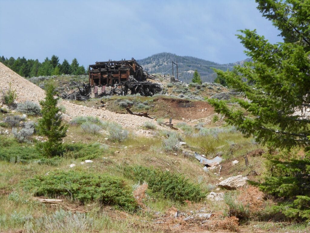 a ruined wooden building in a mountainous landscape. it is where the town of Elkhorn used to be in Montana, but the area is now a ghost town
